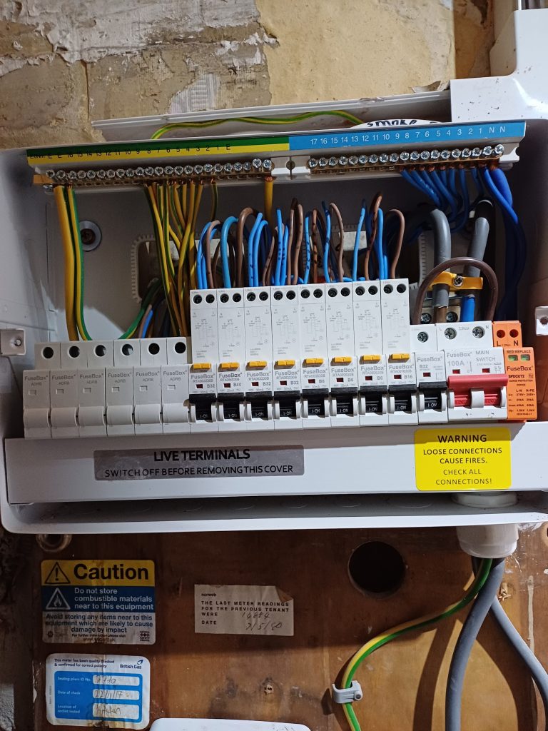 Consumer unit with its cover off, showing neatly dressed circuit wiring