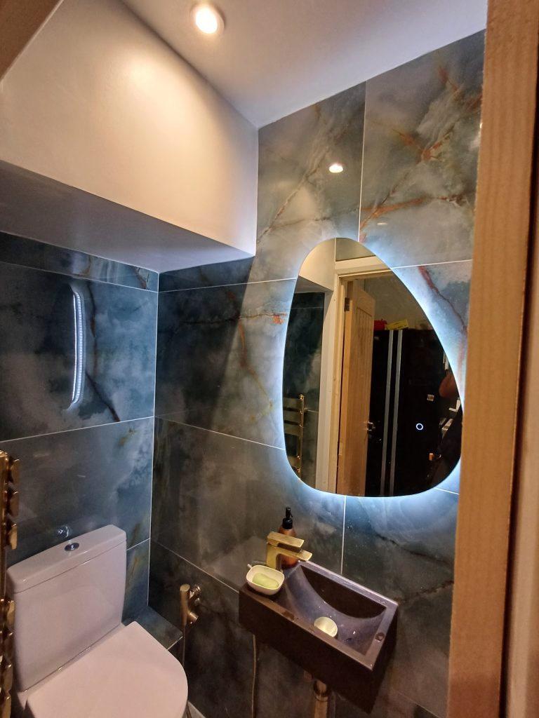 Cloakroom with a backlit mirror and ceiling downlights